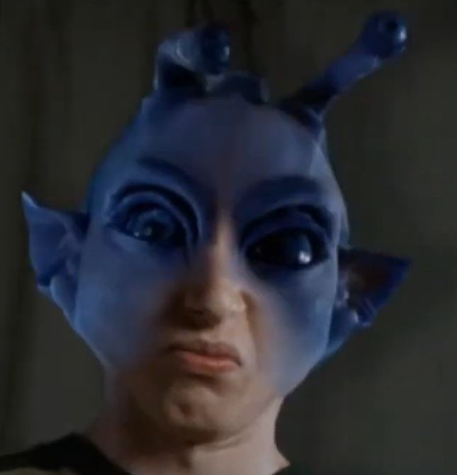 Paulo Costanzo morphing into an alien with big eyes, antenna, pointed ears, and blue skin.