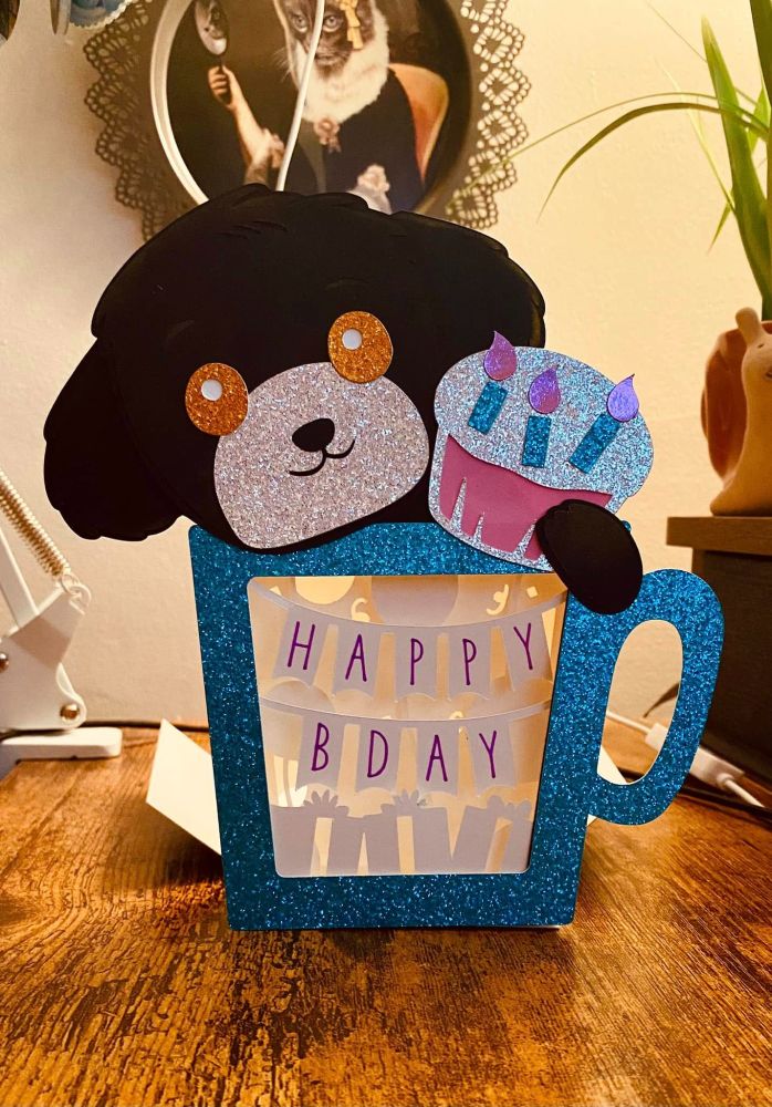 this is a puppy box that I made with my Cricut, it's black with a pink cupcake and lights up. I got the free tutorial at https://jennifermaker.com/hot-chocolate-shadow-box 