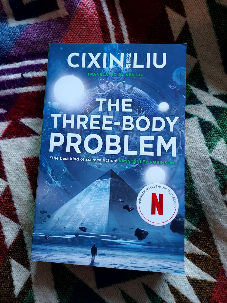Cover of The Three-Body Problem by Cixin Liu. The cover shows white text over a pyramid, floating under three suns.