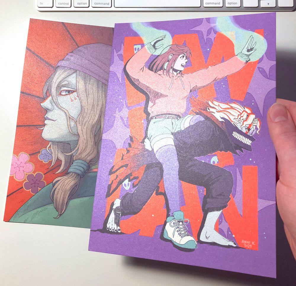 A photo of the two prints, a portrait of Medicine Seller from Mononoke anime (2007) and another one with Momo and Okarun from Dandadan.