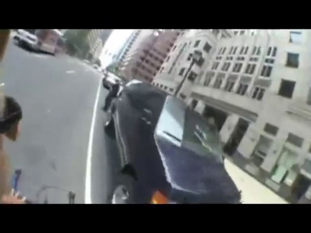 a black car is parked on the side of the road in front of a building