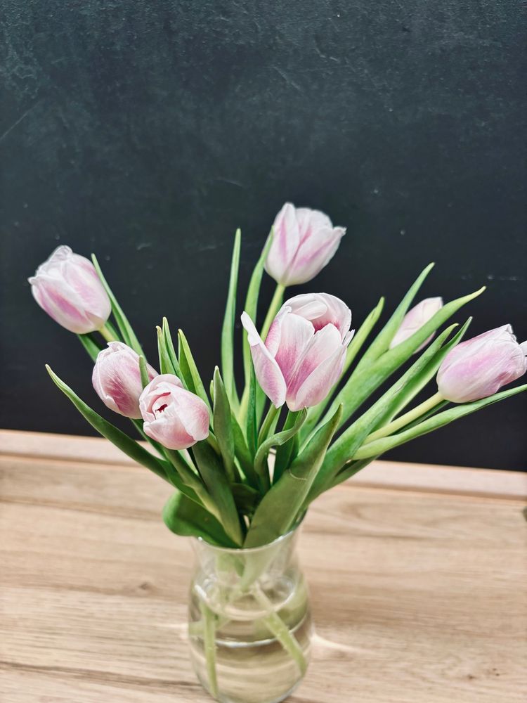 Ein Strauß weiß-lilafarbene Tulpen in einer Vase.