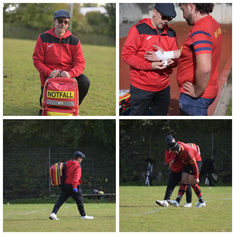 Die Bilder zeigen einen Mann in einer Rolle, die an einen Sportmediziner oder Ersthelfer erinnert, vermutlich bei einem Rugby- oder Fußballspiel.
Oberes linkes Bild: Der Mann kniet auf einem Rasenplatz. Er trägt eine schwarze Mütze, eine Sonnenbrille und eine rote Kapuzenjacke mit schwarzen Einsätzen, darunter ein schwarzes Oberteil und schwarze Hosen. Er stützt sich auf einen großen, rot-gelben Rucksack, auf dem in leuchtend gelben Großbuchstaben das deutsche Wort "NOTFALL" (Notfall) aufgedruckt ist.
Oberes rechtes Bild: Der Mann (mit derselben Kleidung und Ausrüstung) steht auf einer Tartanbahn und versorgt die Hand eines anderen Mannes. Der zweite Mann trägt ein rot-blau gestreiftes Sporttrikot und Jeans. Der Helfer wickelt gerade einen weißen Verband um die Hand des Sportlers.
Unteres linkes Bild: Der Helfer ist auf einem Rasenplatz in einer Ganzkörperaufnahme von der Seite zu sehen, wie er nach links geht. Er trägt den rot-gelben "NOTFALL"-Rucksack auf dem Rücken und hat rote Einweghandschuhe an.
Unteres rechtes Bild: Der Helfer unterstützt einen verletzten oder erschöpften Sportler beim Gehen auf dem Rasenplatz. Der Sportler trägt ein weinrotes Trikot mit gelben Akzenten und schwarzen Hosen. Der Helfer hält ihn mit beiden Armen fest, während sie über den Platz gehen.
Insgesamt zeigen die Bilder die Vorbereitung und Durchführung von Erste-Hilfe-Maßnahmen auf einem Sportplatz.