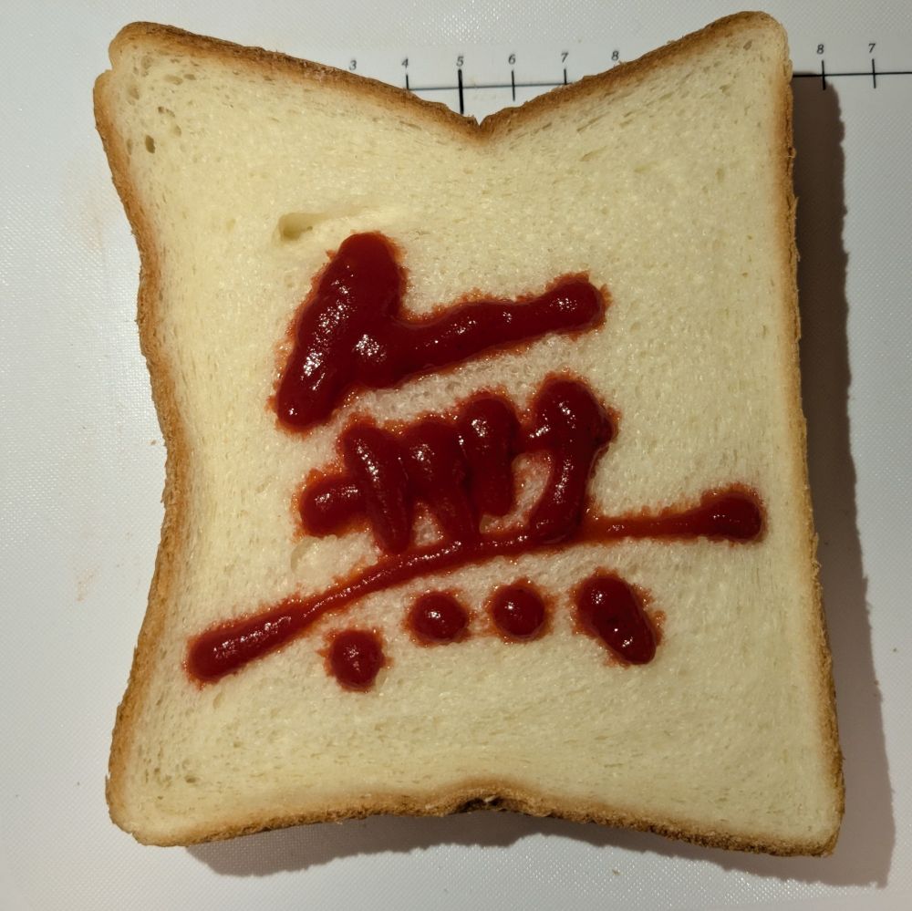 食パンにケチャップで漢字の「無」の文字が書かれている。