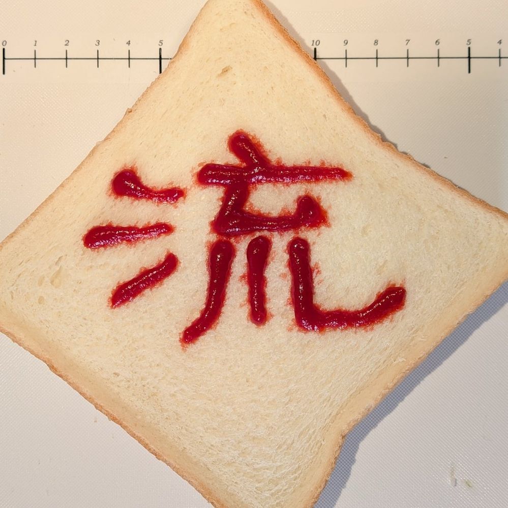 食パンにケチャップで漢字の「流」の字が書かれている。