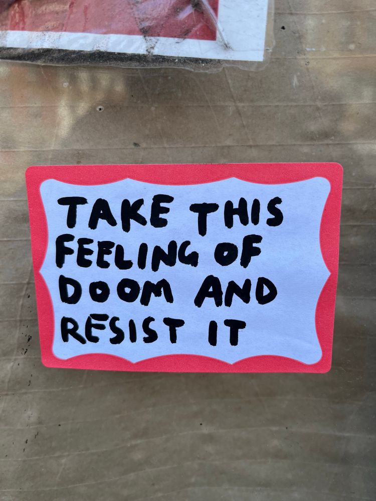 Sticker handwritten in sharpie: "Take this feeling of doom and resist it."