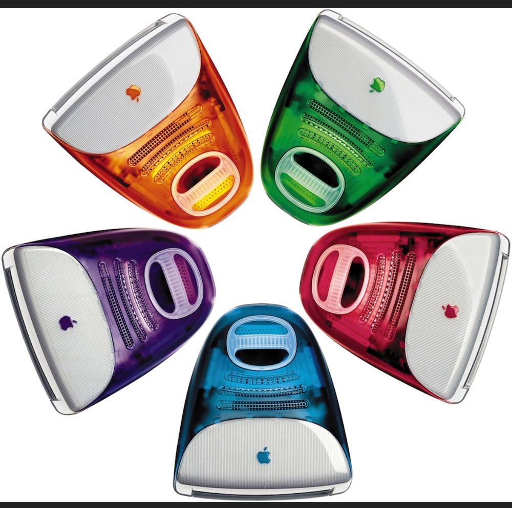 5 1990’s era iMac with transparent colored plastic backs. Clockwise: green, red, blue, purple, and orange