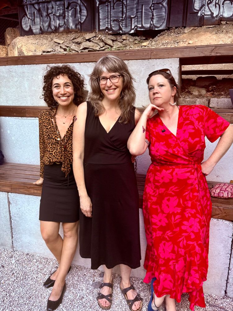Three white women posing in a group. Two look at the camera, the third has one hand on her hip and leans her chin on the other.