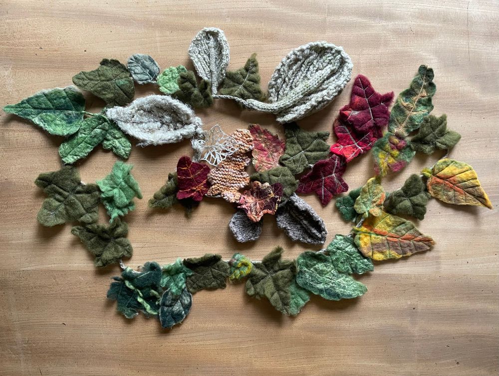 A garland of textile leaves, all different shapes and seasonal colours. Most are wet felted with additional machine embroidery detailing, some are knitted and one is a leaf skeleton made by machine embroidering on soluble fabric. 