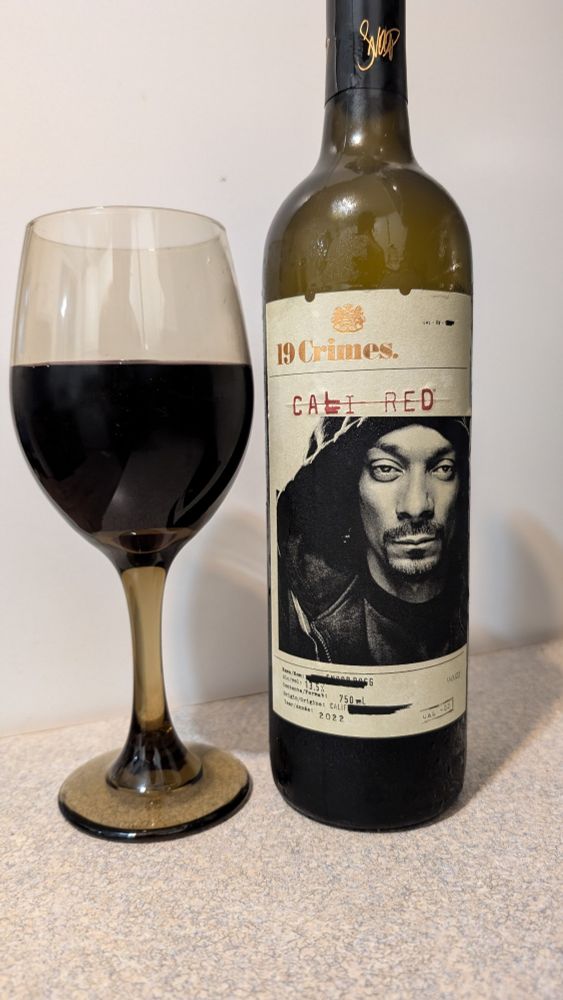 Photo of a glass of red whine and a wine bottle beside it. The bottle says "19 Crimes - Cali Red" and has a picture of Snoop Dogg's face for some reason