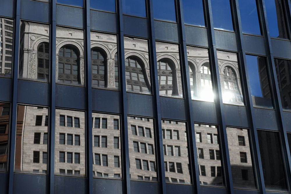 a building's reflection rippling in the glass of the federal building in downtown chicago