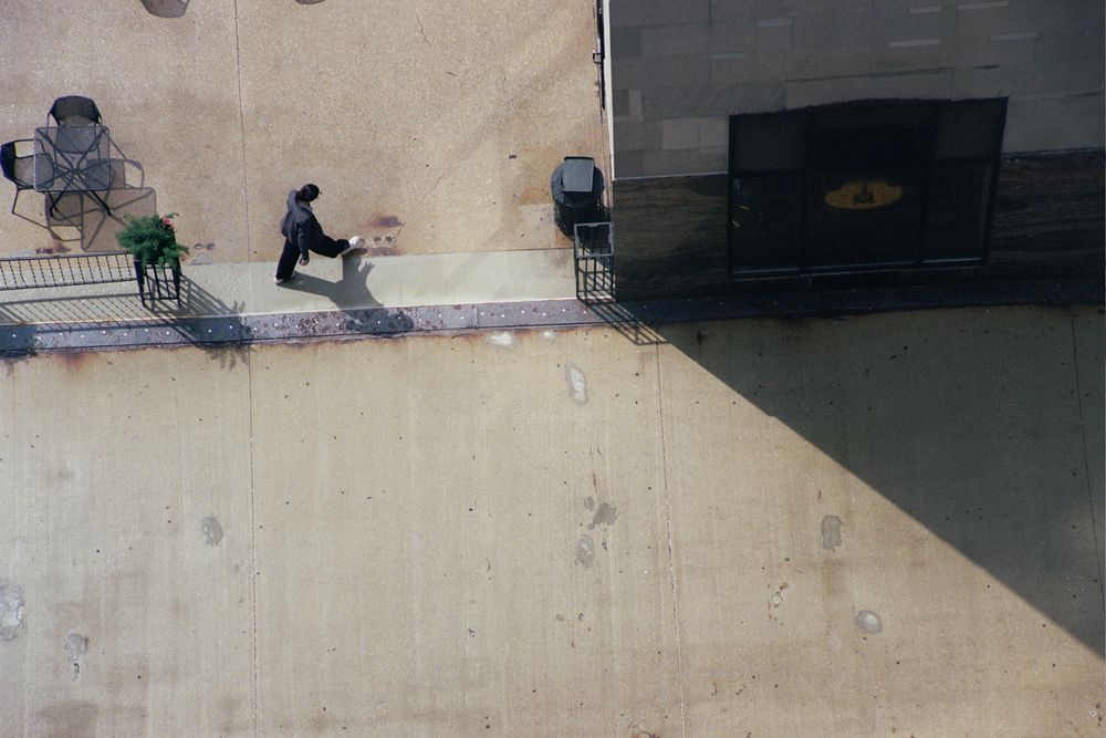 a man's shadow extends outwards from him, shot far from above