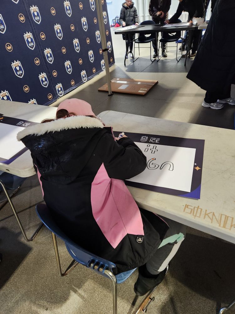 Child making a poster at the Reign FC game. 