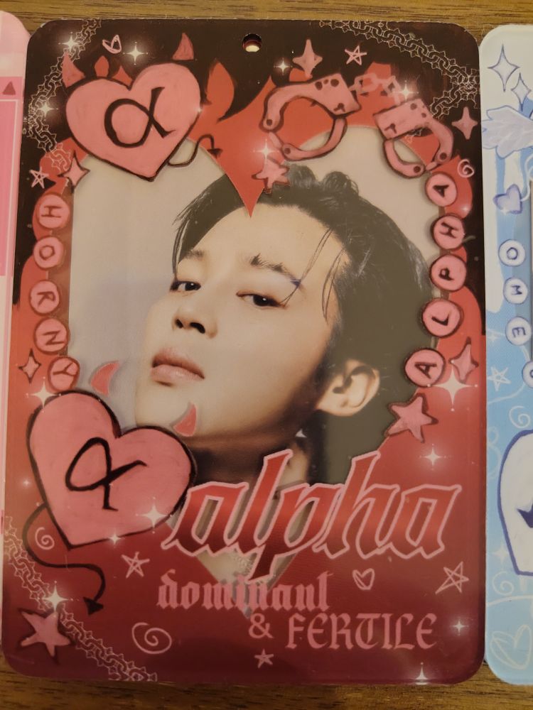 A photo card of jimin in a holder that says alpha dominant and fertile