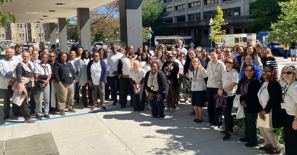 State employees smile together for a group photo outside at State Center.