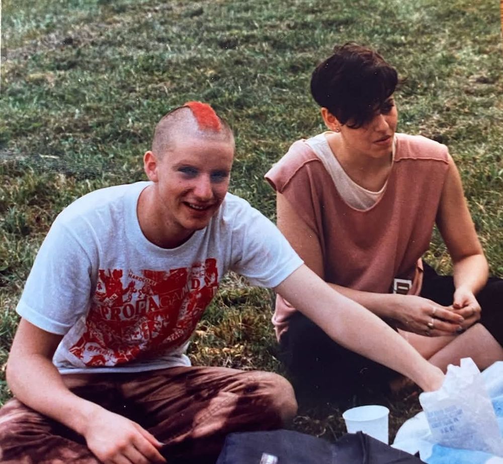 Punk rock days. My girlfriend and I sitting in a park. I have a short red Mohawk. 