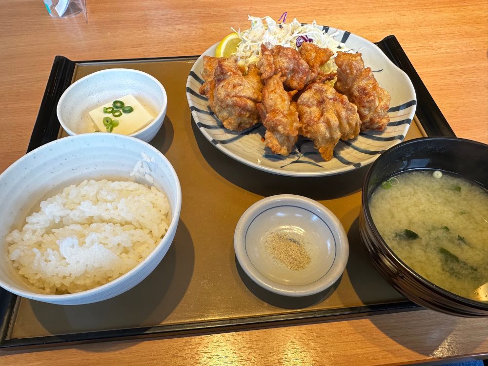 um PF japonês, tem arroz, sopinha de missô, tofu, e frango frito com salada. 