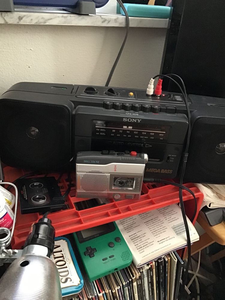 Cassette boom box with another cassette player plugged into it 