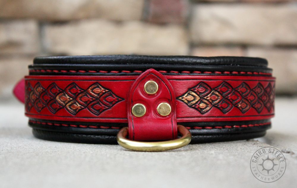 A handmade leather collar. It has a bright red top strap with dragonscale stamping and metallic gold and copper accent scales. It has a distressed black base strap over a black liner, with red stitching. The hardware is solid brass with a drop-D.