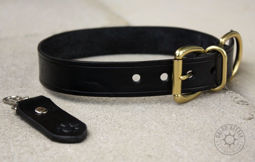 A black leather collar with brass hardware, and a matching keychain
