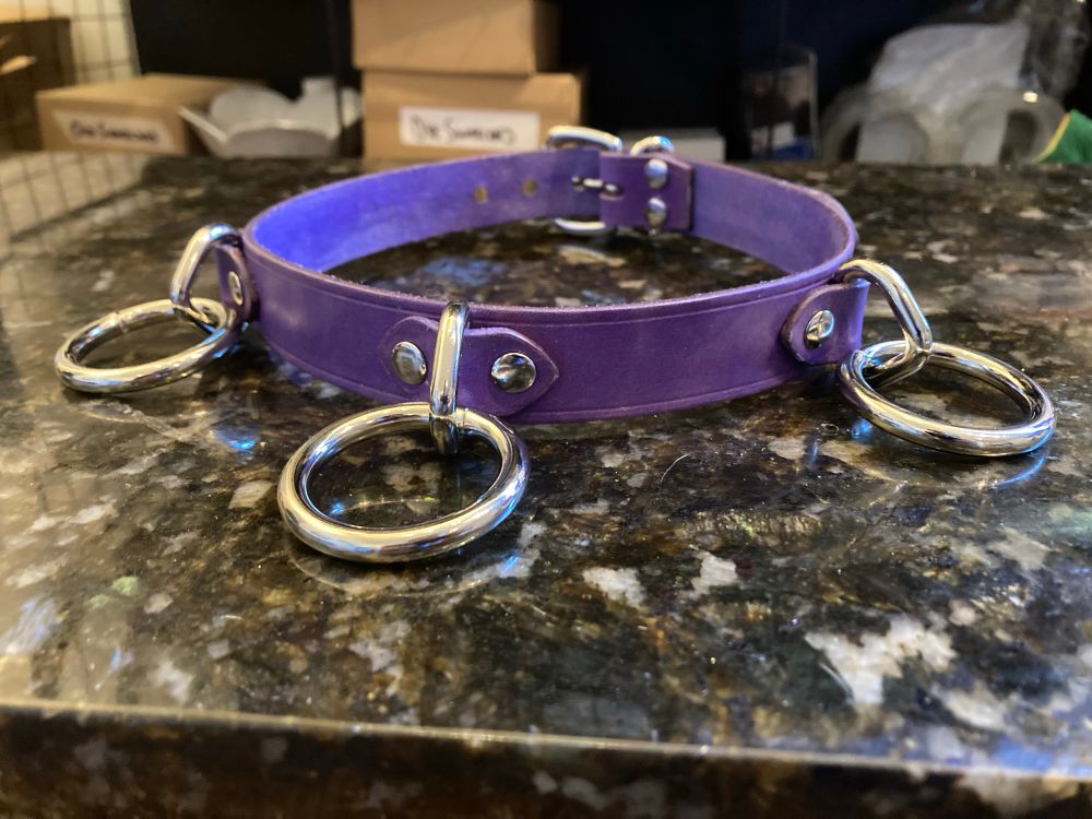 A lilac leather day collar with 3 loop-and-ring attachments