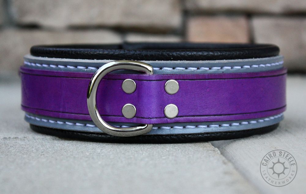 A handmade leather collar in asexual flag colors. It has a violet top strap, gray base strap, black liner, white stitching, and nickel plated brass hardware.