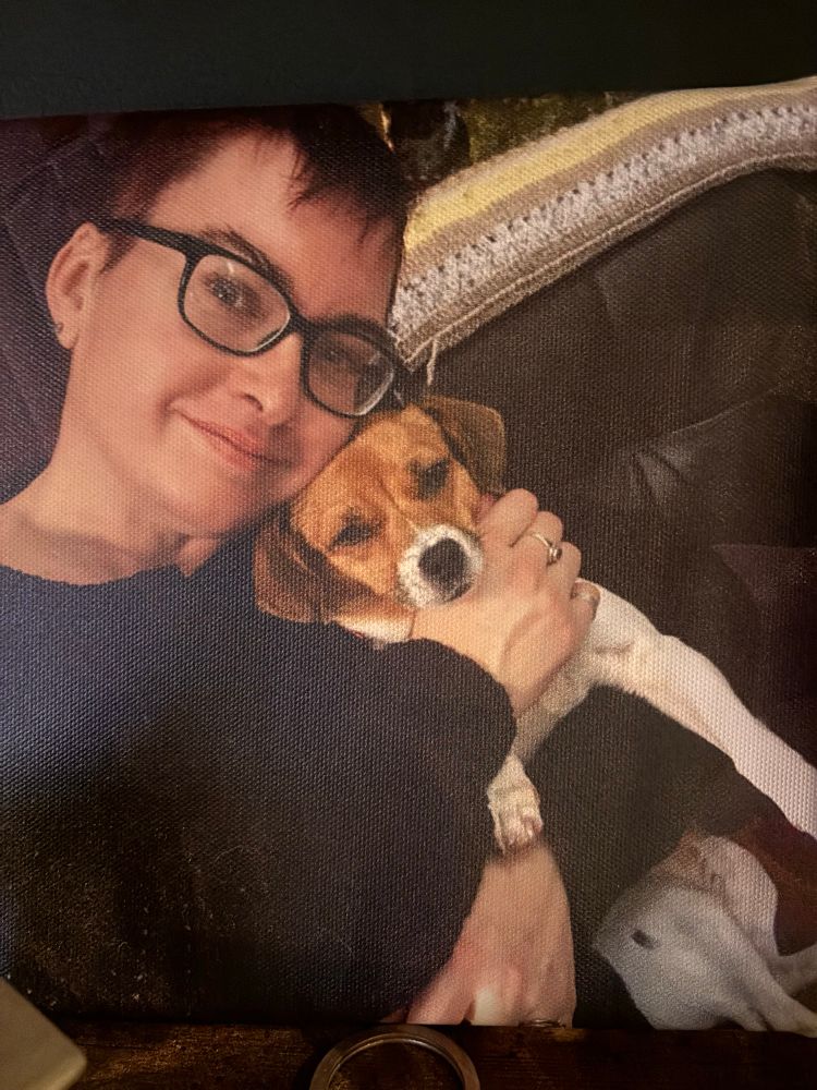 Maria and Winnie, respectively a woman and a dog, sitting on a brown sofa. 