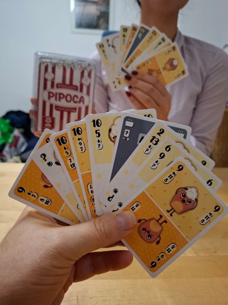 Two players holding up Pipoca cards 