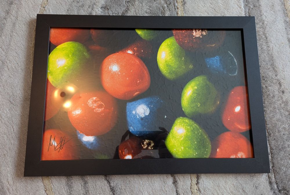 A photo depicting a framed photographic enlargement of a macro photograph of Skittles, shot by Mark on Harman Phoenix 200 colour negative 35mm film