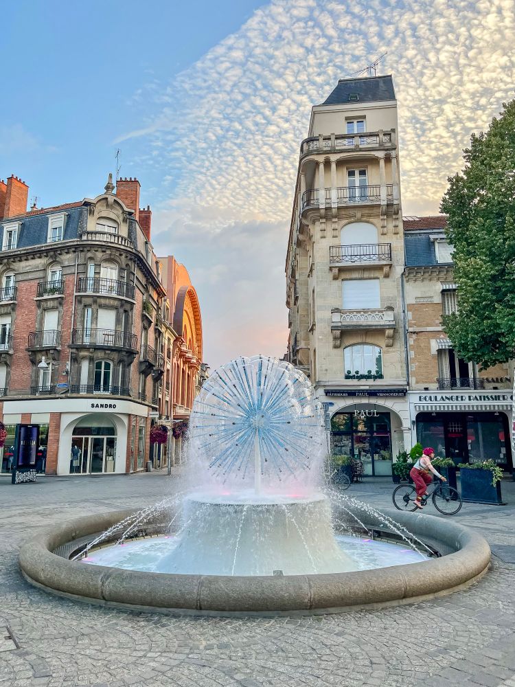People of all ages and abilities walk, cycle, and dine along the low-traffic streets of Reims, which are lined with buildings, trees, and terraces.
