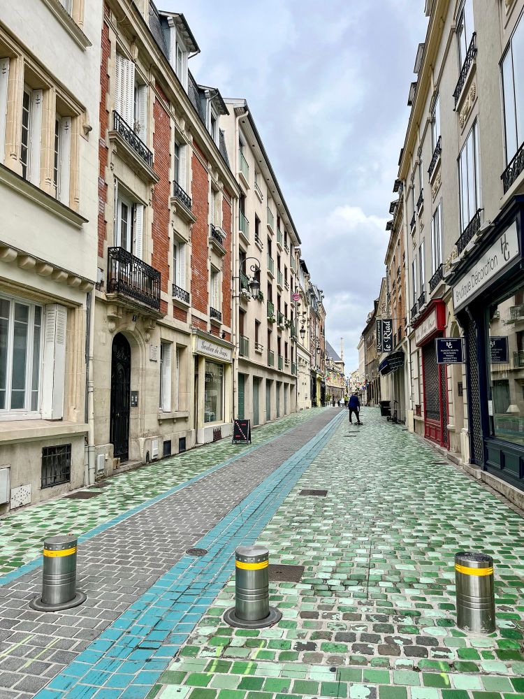 People of all ages and abilities walk, cycle, and dine along the low-traffic streets of Reims, which are lined with buildings, trees, and terraces.