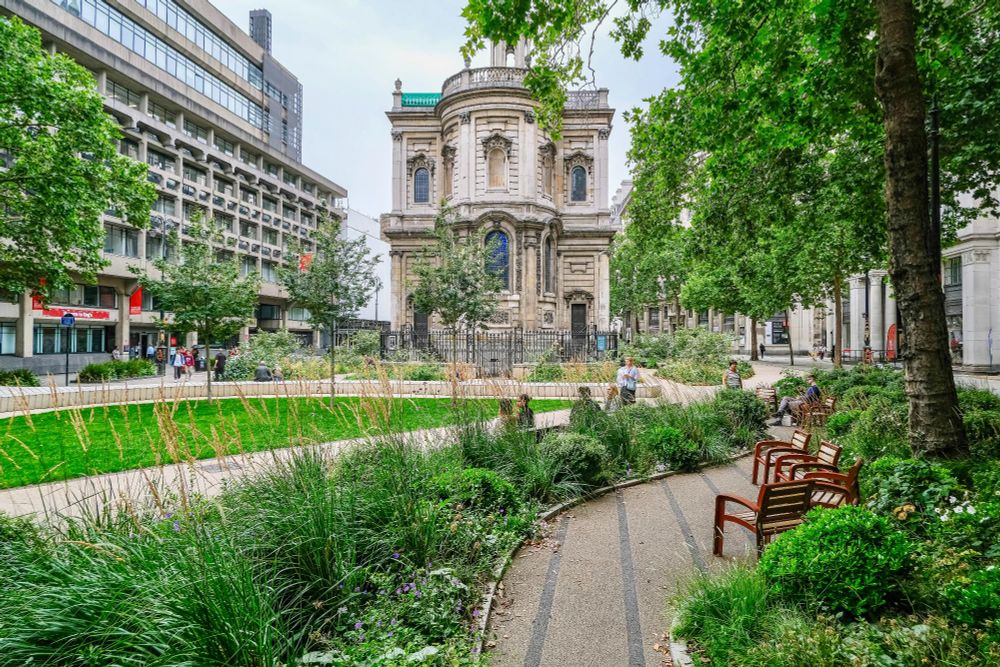 People of all ages and abilities walk, cycle, sit, and socialise on the Strand Aldwych—a former arterial turned pedestrian zone in London, which is lined with buildings, trees, flowers and plantings, benches, and terraces.