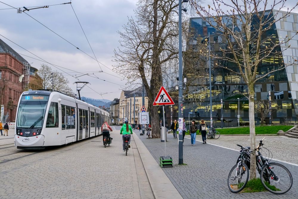People walk, cycle, and ride trams along the low-traffic streets of Freiburg, Germany.