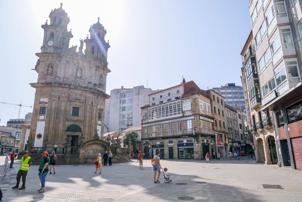 People of all ages and abilities walk, cycle, sit, and socialise on the car-free streets of Pontevedra, which are lined with buildings, trees, benches, and patios.