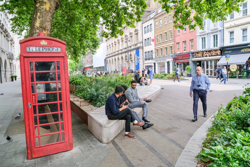 People of all ages and abilities walk, cycle, sit, and socialise on the Strand Aldwych—a former arterial turned pedestrian zone in London, which is lined with buildings, trees, flowers and plantings, benches, and terraces.