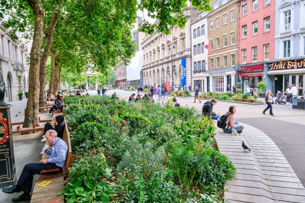 People of all ages and abilities walk, cycle, sit, and socialise on the Strand Aldwych—a former arterial turned pedestrian zone in London, which is lined with buildings, trees, flowers and plantings, benches, and terraces.