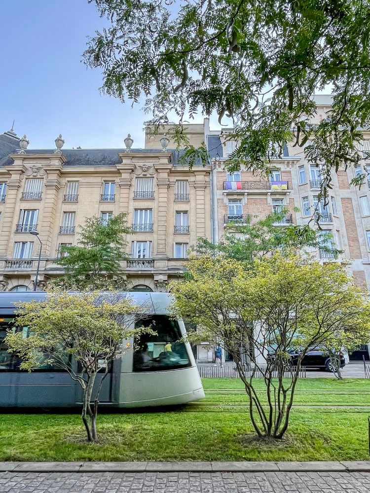 People of all ages and abilities walk, cycle, and dine along the low-traffic streets of Reims, which are lined with buildings, trees, and terraces.