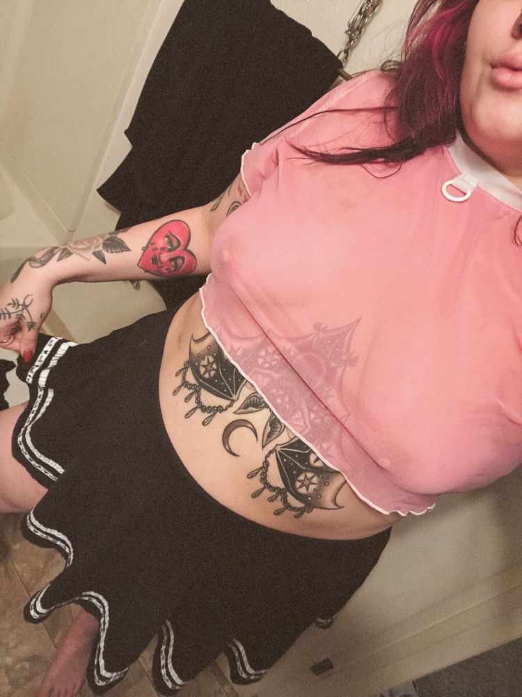 Bratty wearing a pink mesh, see-through top and black miniskirt