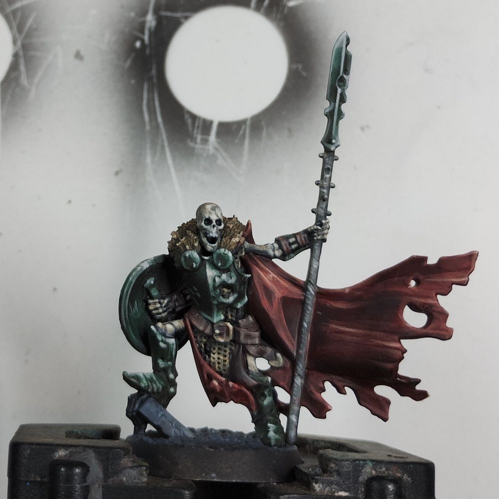 An Underworlds skeleton with green armour and a red cloak.