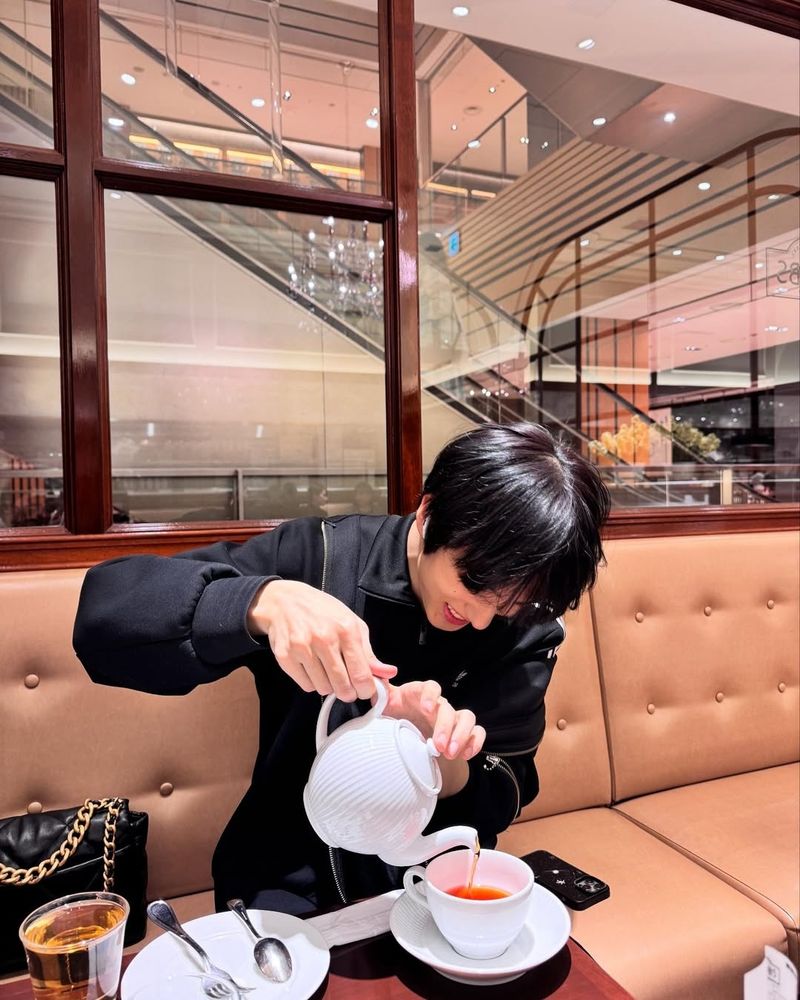 милый джисони наливает в кружку чай