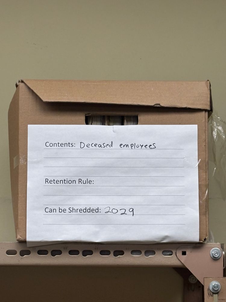 A banker box labeled “contents: deceased employees, can be shredded 2029”