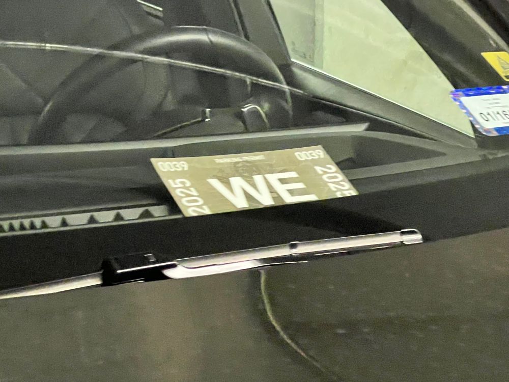 A mercedes prominently displaying a White House parking pass