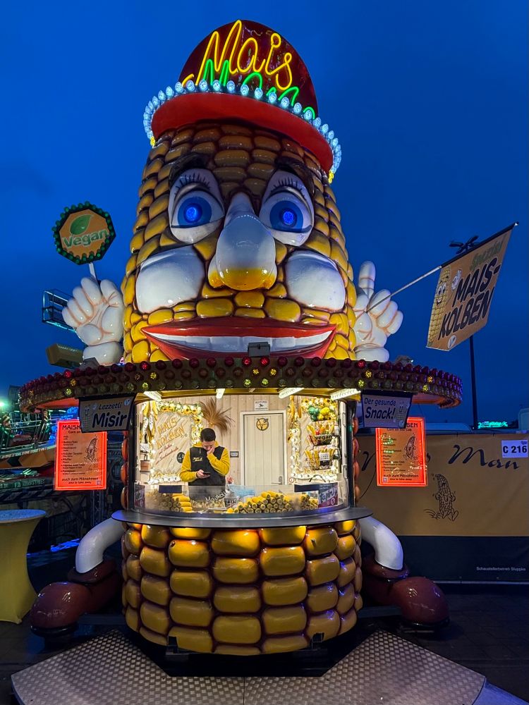Der sehr große Maiskolben Alois als Mais-Verkaufsstand auf dem Dom.