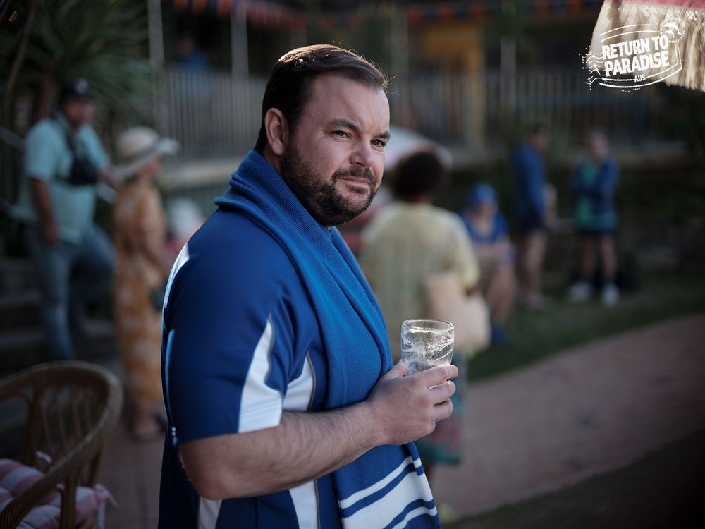 Colin holding a pint glass.