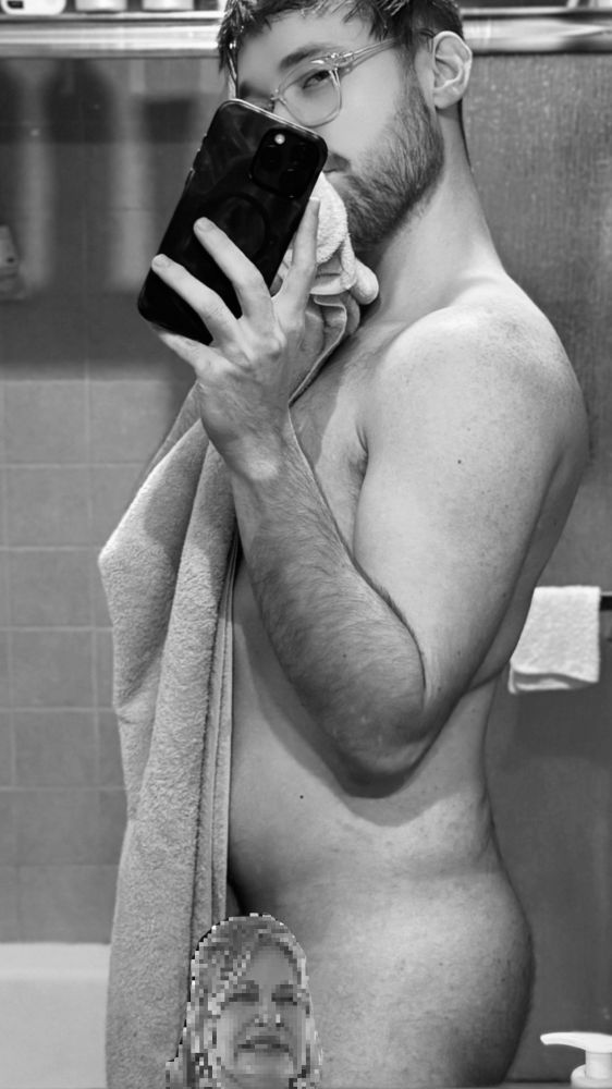 Selfie holding a towel. There appears to be a pixel glitched face covering an exposed area. 