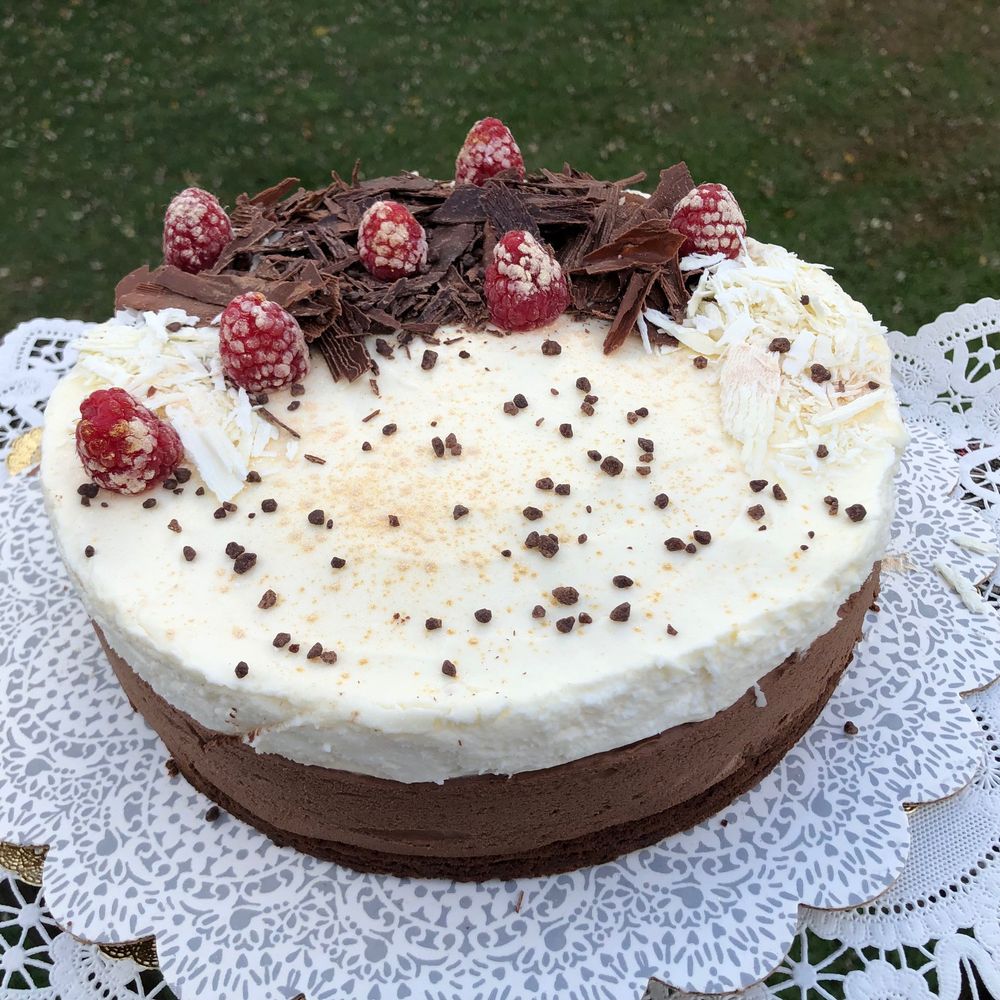 Photo of triple chocolate mouse cake decorated with chocolate "curls" and edible gold-dusted raspberries and chocolate pearl sugar.
Recipe from Cooks Illustrated.