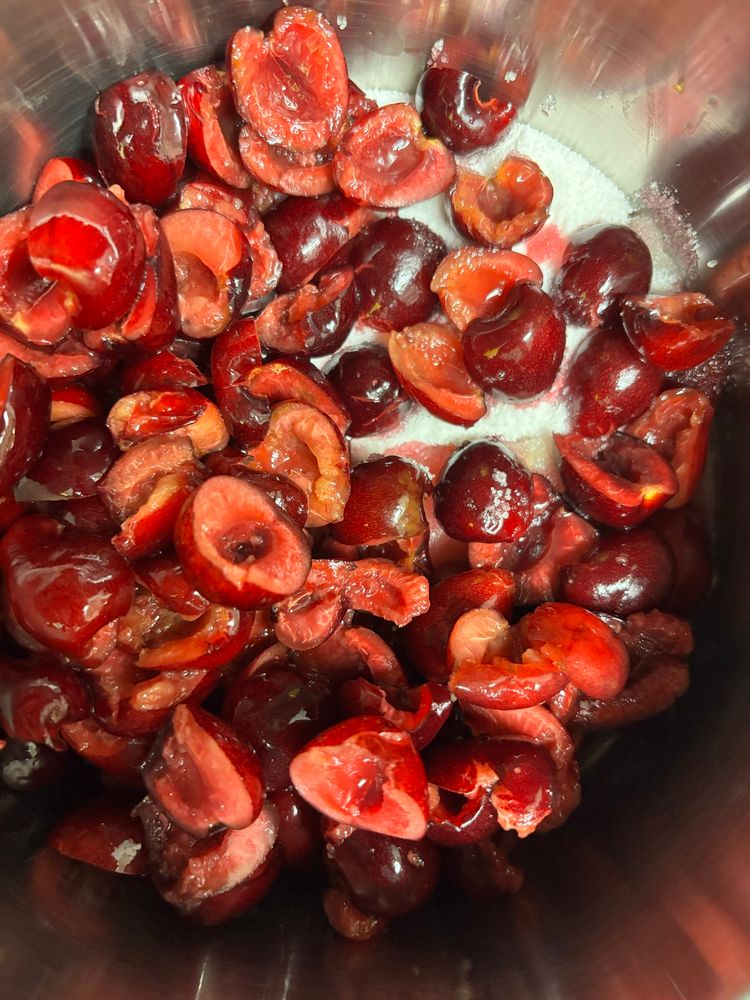 Pitted cherries sliced in half, over some sugar & lemon juice. In a pot ready for cooking