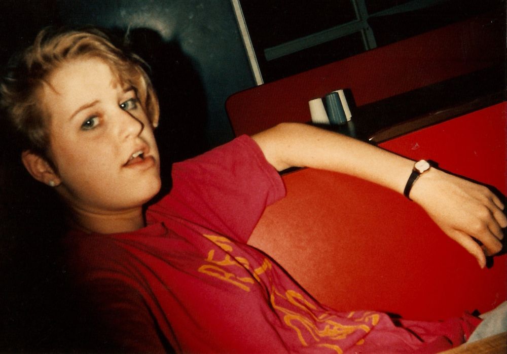 Blonde teenaged girl wearing a pink R.E.M. t-shirt with a bicycle. FYI this is me in the Summer of 1986. 