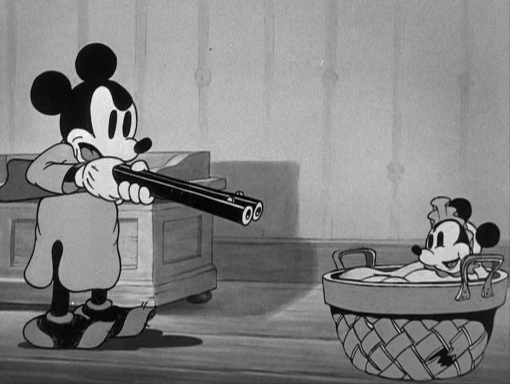 Mickey Mouse points shotgun at small baby 