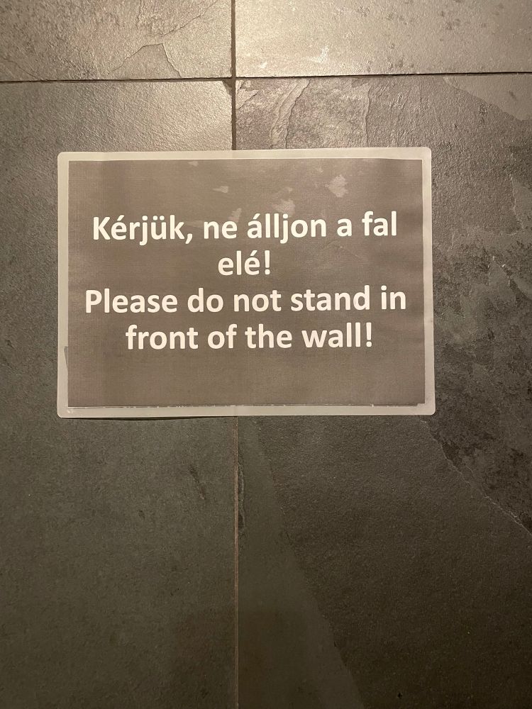 Hungarian sign that reads "Please do not stand in front of the wall!"